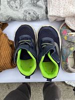 Top view of navy toddler sneakers with neon green lining and strap