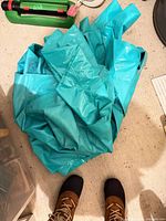 Folded turquoise plastic splash pad on floor