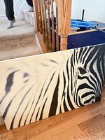 Front view of zebra canvas leaning against railing