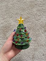 front view of glazed ceramic mini Christmas tree with multicolour bulbs and star topper