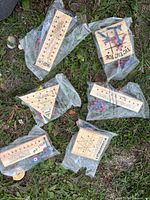 Six sealed wooden peg board games on grass