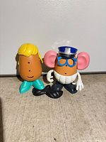 Both Mr. Potato Head figures and loose moustache shown upright on floor