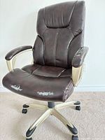 Front view of brown faux leather office chair showing overall style and wear