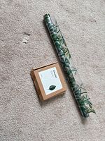 Roll of vine-pattern window film and closed box of plant clips displayed on carpet