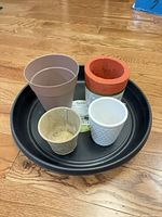 Top view of four pots arranged on black trolley tray