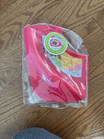 Pink potty training seat in clear package on wood floor
