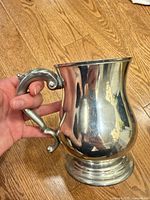 Side view of pewter tankard showing body shape, handle and overall condition