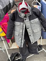 Front view of toddler snowsuit hanging, showing jacket and pants