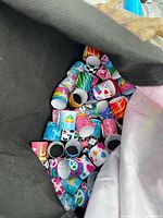 Open bag showing numerous colourful rolled slap bracelets