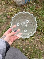 Top view of pressed clear glass dish showing pattern and scalloped edge