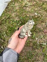 Front angled view of small seated wolf figurine held in hand