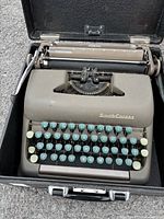 Typewriter inside open case showing keyboard and platen