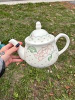 Full view of ceramic teapot showing floral pattern, lid, handle and spout