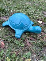 Top view of turquoise ceramic turtle figurine on grass