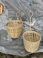 Two woven hanging baskets on plastic sheet