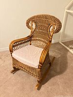 Front view of wicker rocking chair with cushion