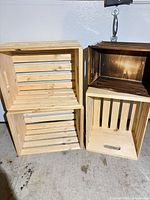 Three light natural-finish slatted crates and one dark stained crate shown side by side