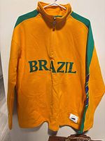 Front view of yellow Brazil quarter-zip jacket on hanger