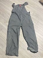 Full view of Dickies hickory stripe overalls laid flat