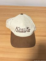 Front view of cap showing logo and brown brim