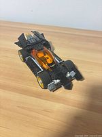 Assembled LEGO Batmobile displayed on wood surface