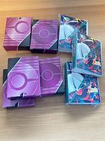 Lot overview showing eight purple card sleeve packs and four teal mini binders