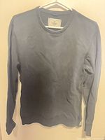 Front view of dark grey Reigning Champ crewneck sweatshirt on hanger