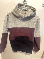 Front view of Tna colour-block hoodie showing kangaroo pocket and tri-colour design