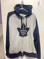 Front view showing logo, zipper, color scheme and size tag