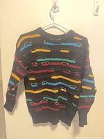 Front view of black multicolour wool sweater on hanger