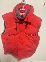 Front view of red Penfield Trailwear down puffer vest on hanger