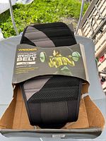 Front of Weider contoured weight belt in torn box showing product name and size