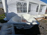 front view of white corner jetted tub with jets and piping visible