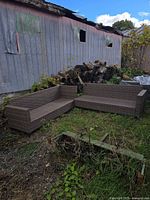 Two brown resin wicker sectional sofa frames placed outdoors