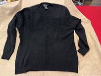Front view of black cashmere sweater laid flat