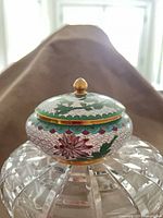 Side view of Japanese cloisonné bowl with lid on cut-glass stand