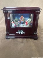 Front view of wood music box with glass window and bow accent
