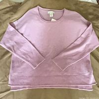 Front view of lilac cashmere sweater laid flat