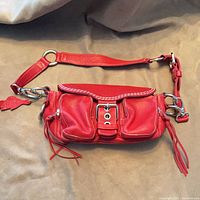 Front view of red Roots purse with strap attached
