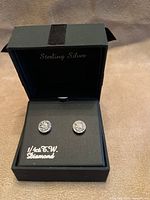 Earrings displayed in open box showing diamond studs