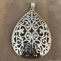 Front view of sterling silver filigree teardrop pendant showing scroll pattern