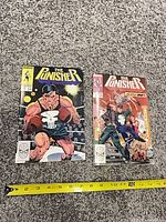 Both comic books front covers with tape measure for scale