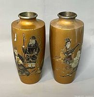 front view of both gold-tone vases displaying etched painted Asian figures