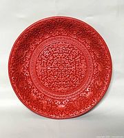 Front view showing full carved surface of red cinnabar plate