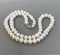 Full view of pearl necklace coiled showing clasp