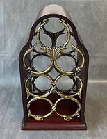 Front view showing arched wood frame and six brass-tone rings