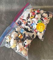 two Ziploc bags filled with Snoopy figurines
