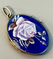 Front view closed locket showing rose enamel design