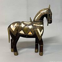 right side view of wood horse with brass inlay