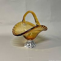 Full view of amber art glass basket with handle and foot